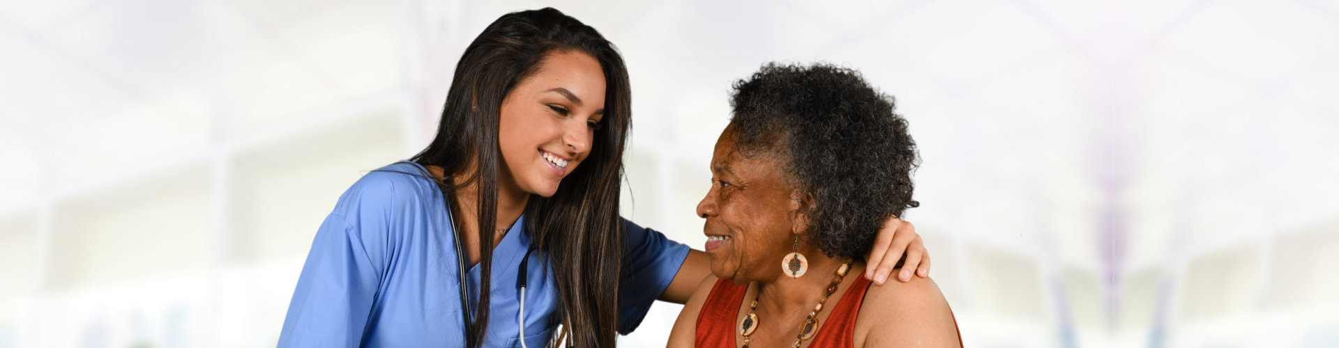 nurse and senior woman looking each other