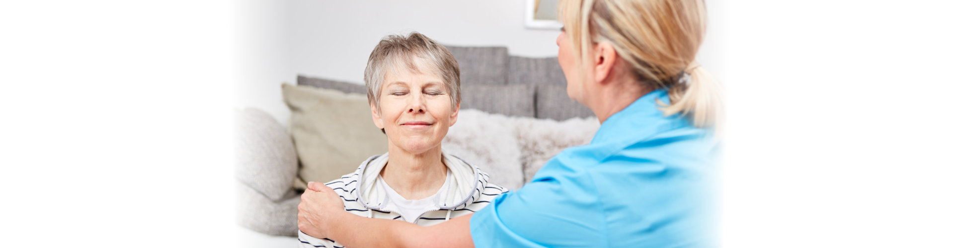 old woman closing her eyes while her nurse holding her